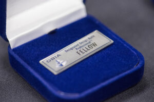 Close-up shot of DBIA Fellows badge with "DBIA Designated Design-Build Professional Fellow"