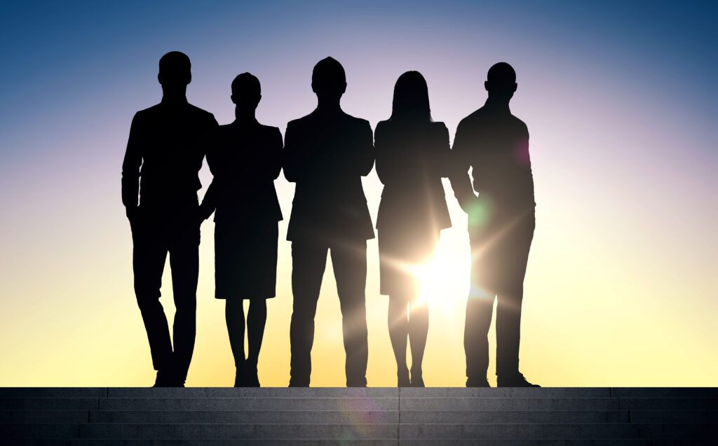 decorative image of five people in silhouette standing in business attire with lens flare coming from behind them