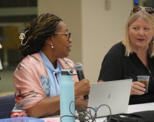Jumoke Akin-Taylor, awards juror for DBIA speaks into microphone during debate round of judging for awards