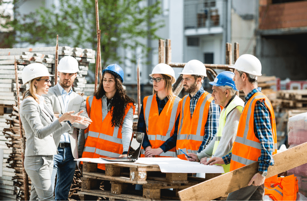 Group of diverse young construction workers discuss progress on a job site