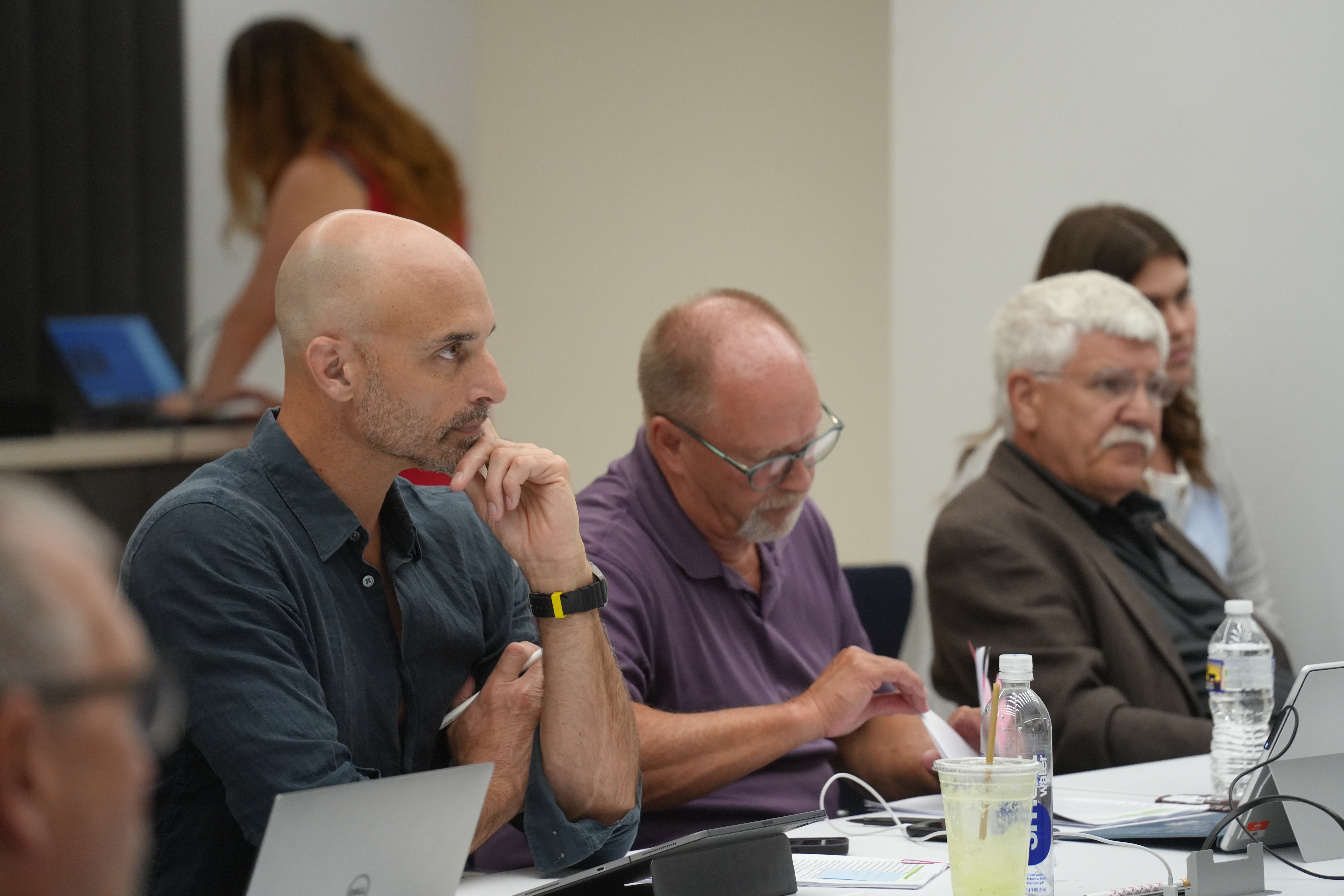 Three men listen during awards jury deliberation
